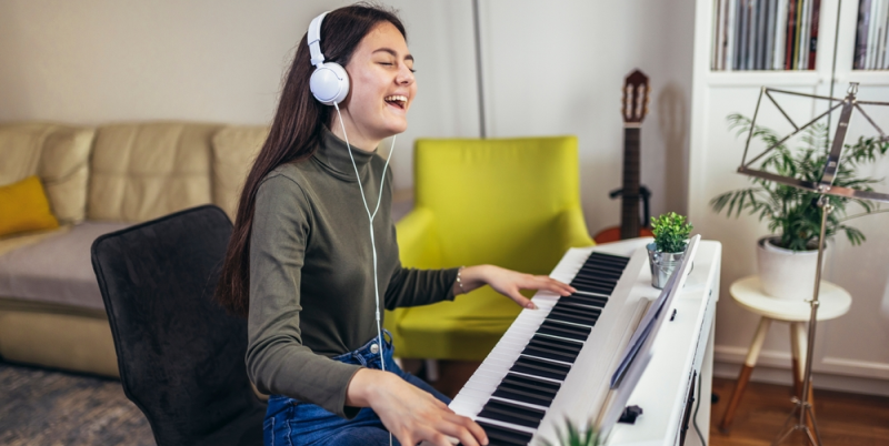 Adolescente alegre toca instrumento musical en casa