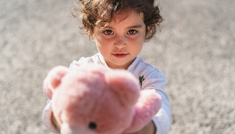Niña pequeña comparte un oso de peluche