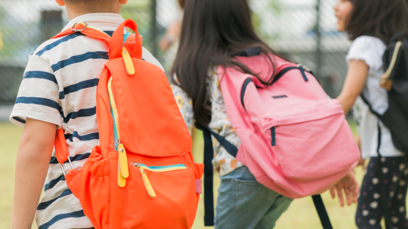 Niños con mochila en colegio privado