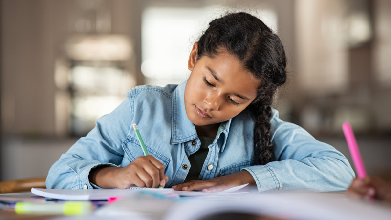 Niña de primaria trabaja ejercicio de lectura y escritura