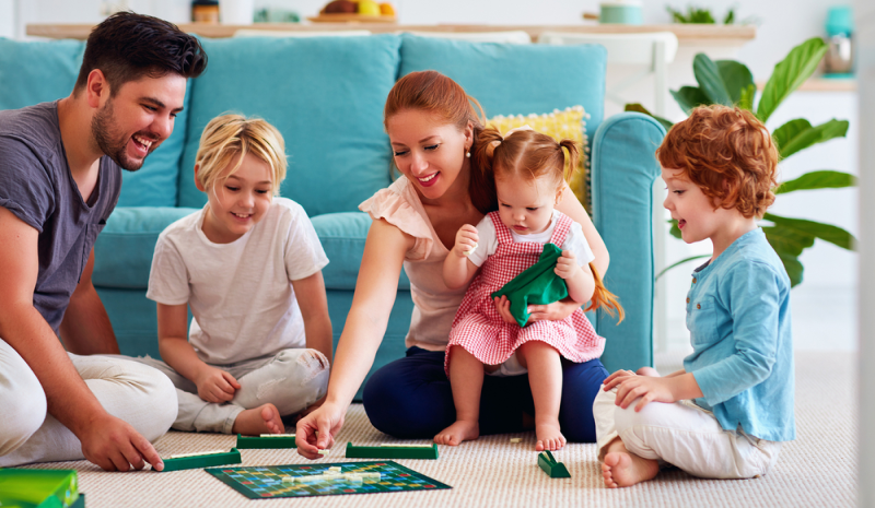 Familia con niños de preescolar juega juegos de mesa