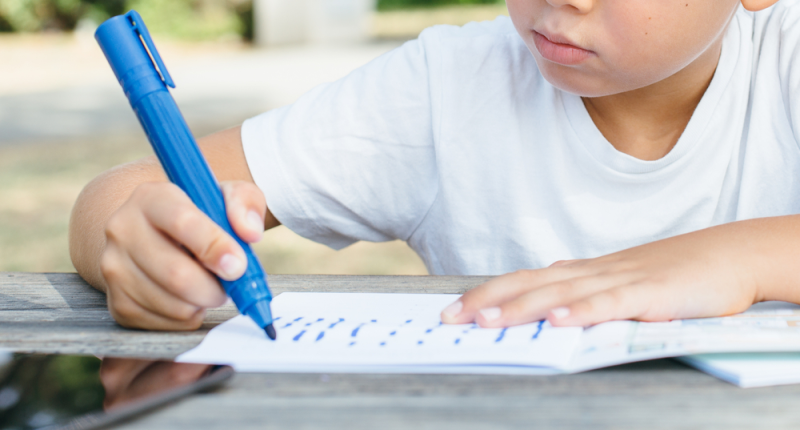 Niños pequeño usando libro para aprender a leer y escribir