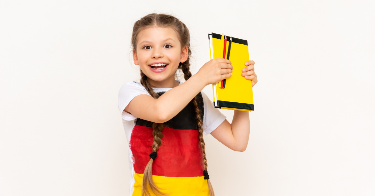 Niña de primaria sostiene libro de alemán