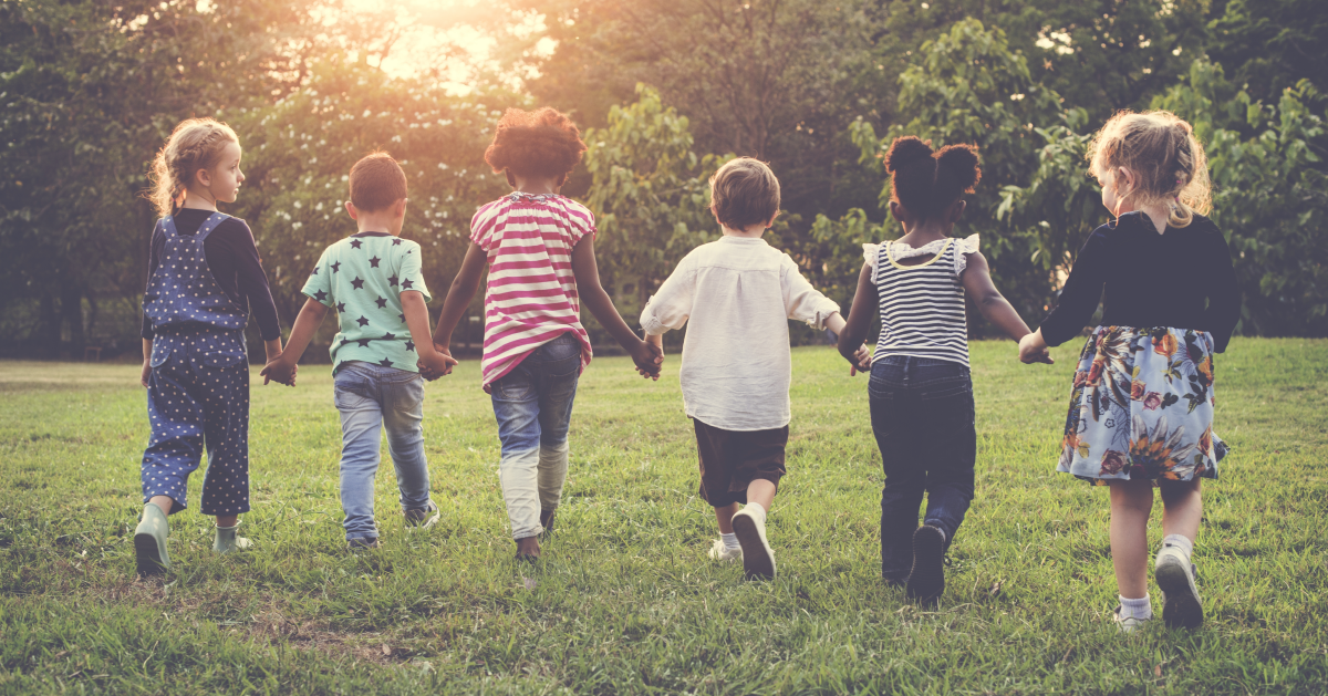 Niños de preescolar jugando tomados de la mano