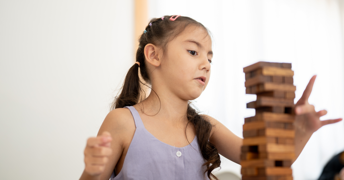Niña jugando Jenga para mejorar su atención