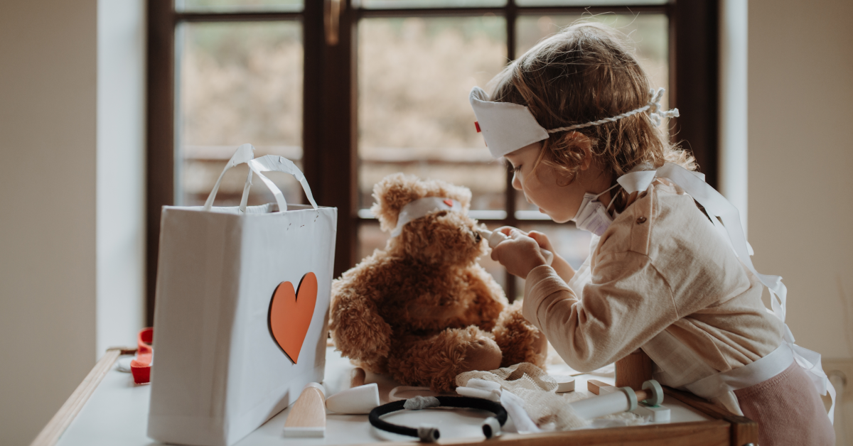 Niña practica empatía, cura oso de peluche