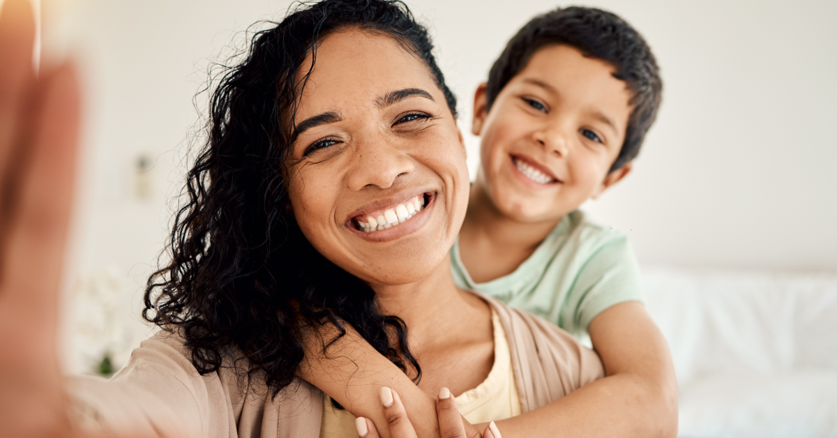 Mamá e hijo de primaria sonríen felices a cámara